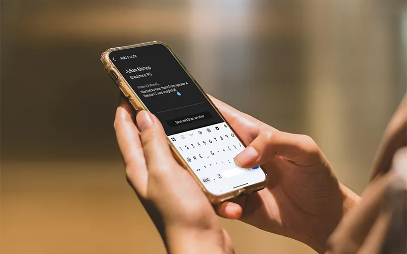 Person typing a note into the ContactScanning app on their smartphone