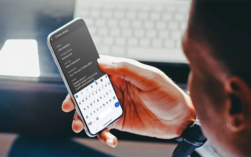 A man sitting at a desk adding notes in the ContactScanning app